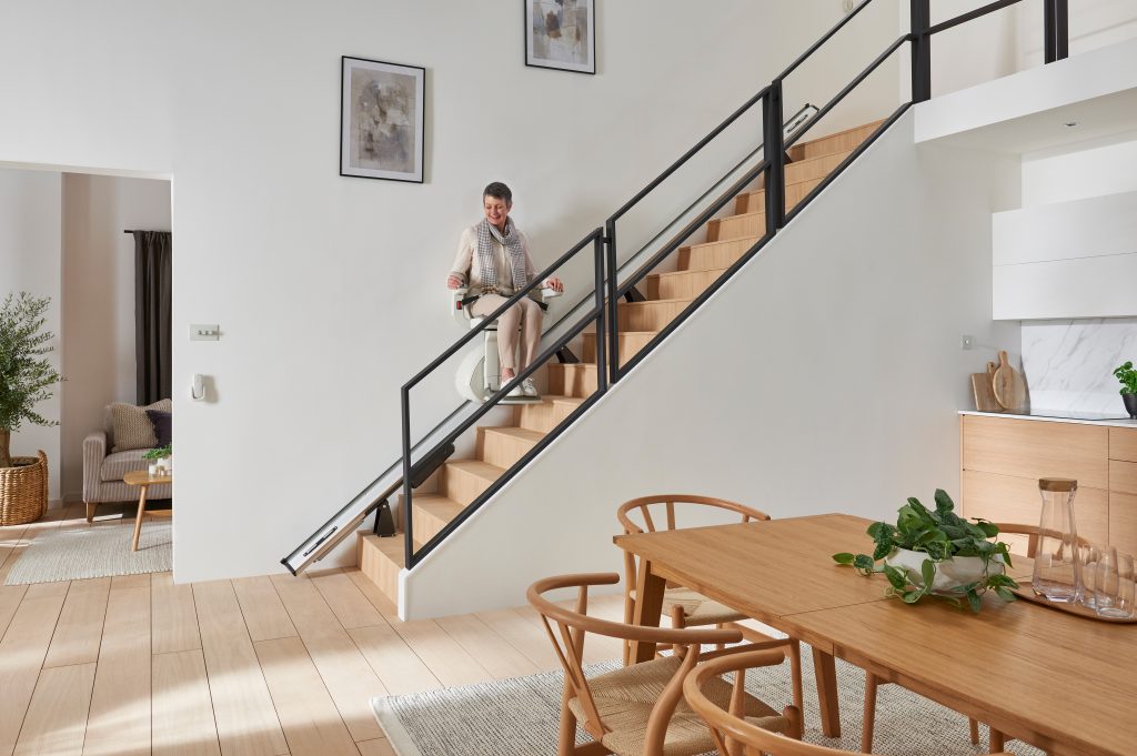 A woman travels in an Access BDD stairlift fitted by Adaptmyhome